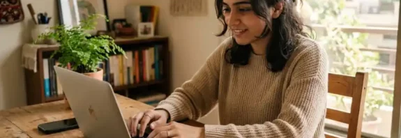 A person using free ChatGPT on a laptop in a bright home office, 2026